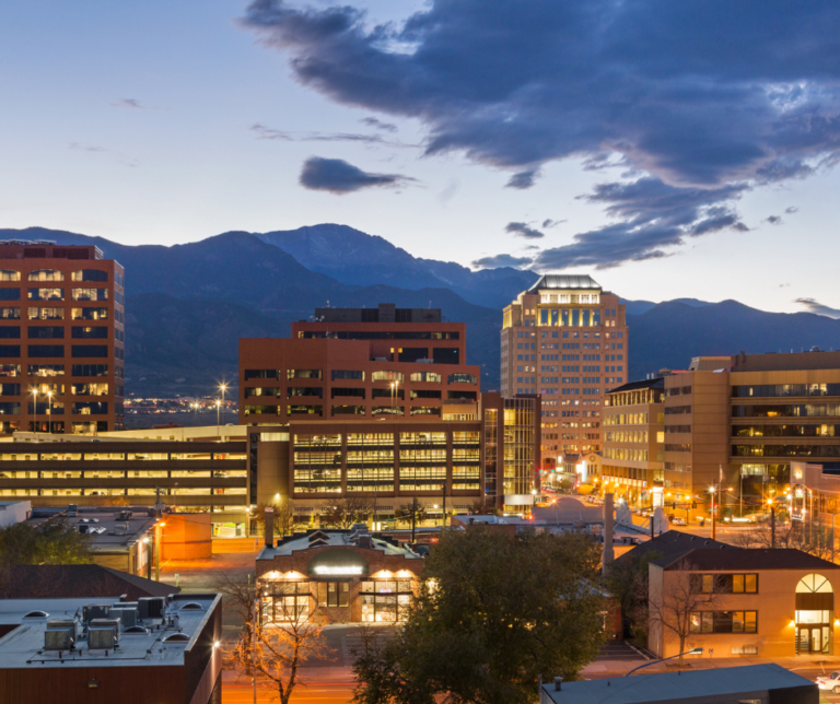 Colorado Springs downtown city skyline at dusk with Pikes Peak mountain in the background